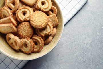 Bowl with Danish butter cookies on grey background, top view. Space for text