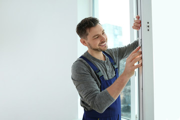 Canvas Print - Construction worker installing plastic window in house