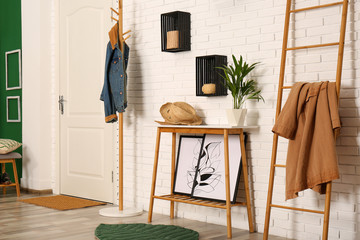 Canvas Print - Stylish hallway interior with hanger stand, table and decorative wooden ladder