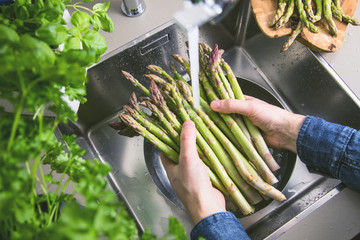 Waschen von frischem Spargel in Spülbecken