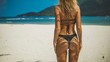 © South House Studio - amazing back shot of bikini girl stands on white sand beach, her butt in sand