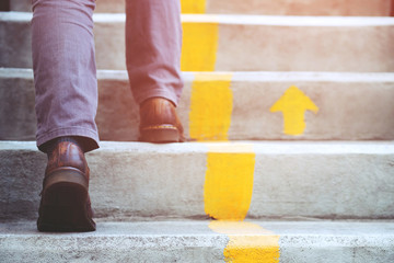 modern businessman working close-up legs walking up the stairs in modern city. in rush hour to work 