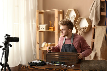 Wall Mural - Young male blogger recording video in workshop