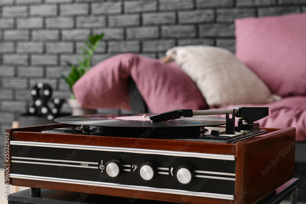 Record player with vinyl disc in room
