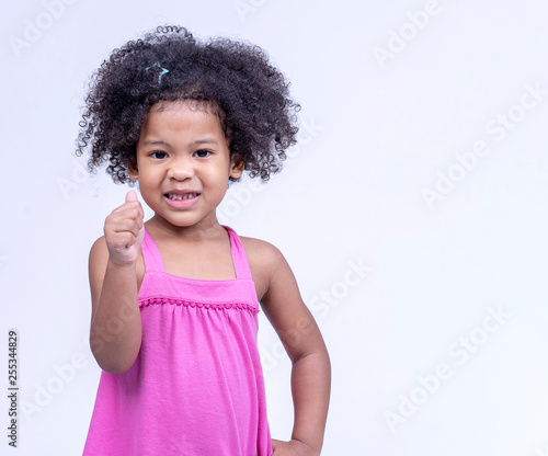 Happy Little Girl Standing In A Casual Outfit Showing Thumbs Up