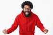 © Cookie Studio - Indoor shot of confident and optimistic african american bearded man in glasses and red hoodie bending towards camera supportive, clenching fists in cheer and smiling broadly being fan over gray wall
