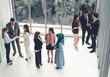 © InfiniteFlow - Many business people gathering in modern office building for business conference in the city. Businessmen and businesswomen communication and human resources concept.