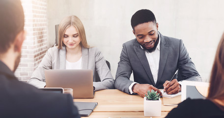 Managers working in office, using laptop and writing ideas