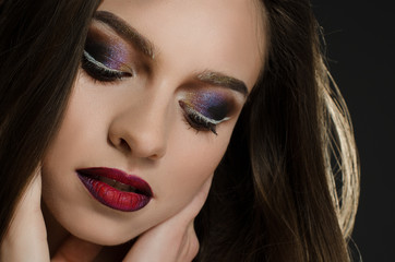  Young adult girl with beautiful evening makeup on a black background
