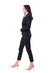 Wall Mural - Side view of serious confident successful business woman manager walking. Full body isolated on white background.