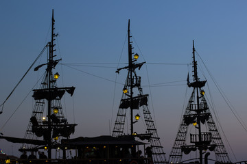 Wall Mural - twilight medieval pirates ship silhouette soft focus shape with lantern illumination 