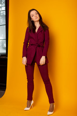 Wall Mural - Sexy elegant woman natural beauty fashion style clothes female burgundy trouser suit, casual formal  dress lady glamour model trend dark hair brunette makeup accessory.