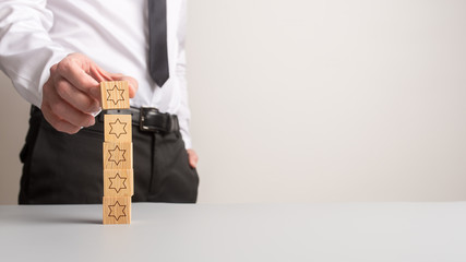 Wall Mural - businessman stacking five wooden cubes with stars on them