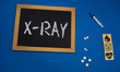© taiga - wooden tablet on blue medical table with the word X-RAY