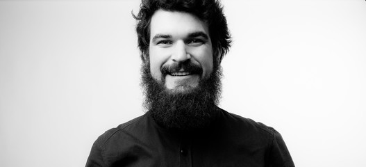 Black and white photography. Portrait of smiling bearded man looking at camera, isolated background