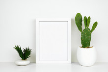 Mock Up White Frame With Cactus And Succulent Plants On A Shelf Or Desk. White Shelf And Wall. Portrait Frame Orientation.