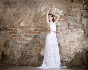 Greek style woman in long white dress. Fashion model