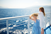 Adorable Young Girls Enjoying Ferry Ride Staring At The Deep Blue Sea. Children Having Fun On Summer Family Vacation In Greece.