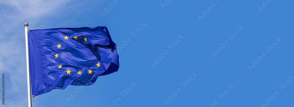 Flag of the European Union waving in the wind on flagpole against the sky with clouds on sunny day, banner, close-up - obrazy, fototapety, plakaty 