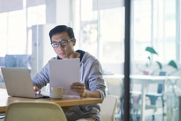 Portrait of Asian businessman working on laptop in office