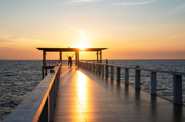 Landscape of bridge in sea on tropical beach and sunset sky background .