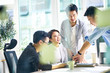 © imtmphoto - group of four asian teammates working together discussing business in office