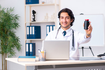 Young handsome doctor working in clinic 