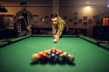 Wall Mural - Male billiard player with cue aiming at the table