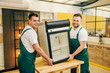 © Nomad_Soul - Workers in uniform installs refrigerator at home