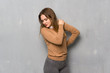© luismolinero - Teenager girl over textured wall suffering from pain in shoulder for having made an effort