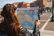 © OlgaKhorkova - Young woman  looking at paper map of Venice on sunny day, many tourists on background