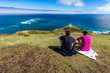 © Beautyness - Couple enjoying the view Lighthouse at Cape Reinga, with Tasman Sea and Pacific, Northland, New Zealand