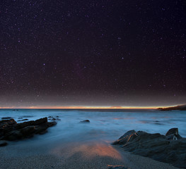 Wall Mural - night sky from a rocky beach. cornwall, uk.