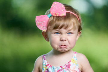 Portrait of a angry little girl with blue eyes