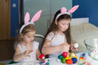 © erainbow - Girls paint easter eggs
