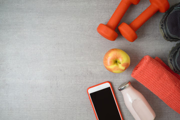 Wall Mural - Fitness background with dumbbells, protein shake, apple and towel.