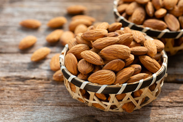 Wall Mural - Almonds nuts in wooden bowl on wood table.