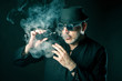 © Grispb - A man smokes electronic cigarettes. Aged man in smoke. Vape. Cloud of steam. A cloud of vapor.
