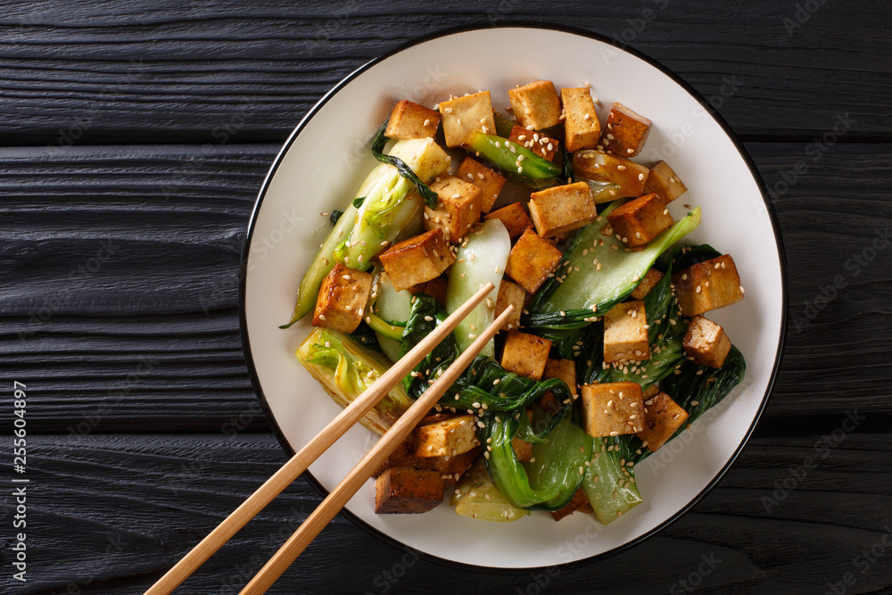 Stir fry tofu with bok choy and sesame seeds close-up on a plate. horizontal top view - obrazy, fototapety, plakaty 