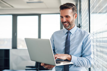 Businessman in modern office working on laptop