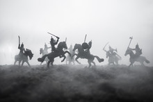 Medieval Battle Scene With Cavalry And Infantry. Silhouettes Of Figures As Separate Objects, Fight Between Warriors On Sunset Foggy Background. Selective Focus