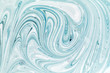 Abstract background for layouts. Stirring light turquoise and white paint close-up. Bright photo.