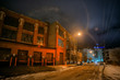 Industrial winter street city night scene with vintage factory warehouses and the Chicago skyline