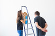 © satura_ - People, renovation, pet and repair concept - Portrait of funny man and woman with cat doing redecoration in apartment