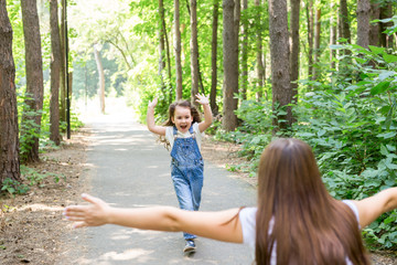 Family and nature concept - Young woman with little girl have fun outdoors