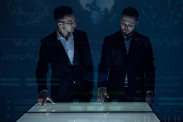 Poster - The two businessmen working with a display on the hologram background