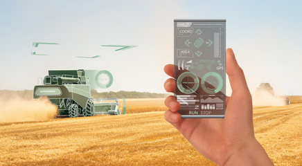 Aufkleber - Farmer uses a futuristic smartphone to control autonomous harvester. Smart farming concept