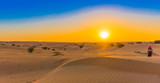 Fototapeta  - Jeep safari at sunset over sand dunes in Dubai Desert Conservation Reserve, United Arab Emirates. Copy space for text.
