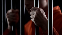 Desperate Criminal Holding Jail Bars Feeling Regret For Committing Crime Closeup