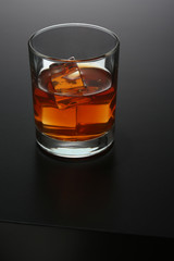 Wall Mural - Glass of whiskey on black gradient background